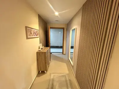 a hallway leading to a room with a window at Deluxe 1BHK Apt in JVC, Self check in ! in Dubai