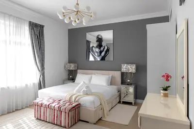 a bedroom with a large white bed and a table at Spacious 2BR with Pool & Private Beach Access in Dubai