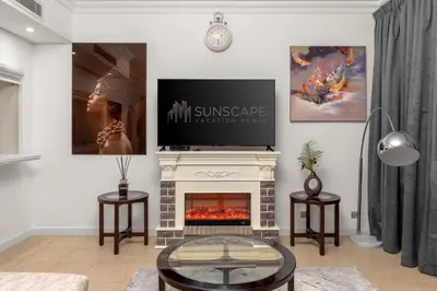 a living room with a fireplace and a flat screen tv at Spacious 2BR with Pool & Private Beach Access in Dubai