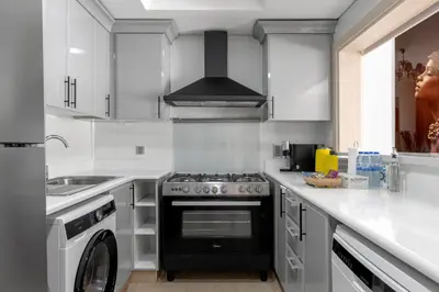 a kitchen with a stove and a sink at Spacious 2BR with Pool & Private Beach Access in Dubai