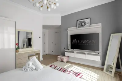 a bedroom with a tv and a bed and a mirror at Spacious 2BR with Pool & Private Beach Access in Dubai
