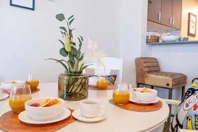 a table with bowls of oranges and glasses of orange juice at Marina Majesty- Homely & Cozy 2BR, CanalView, Central Location in Dubai