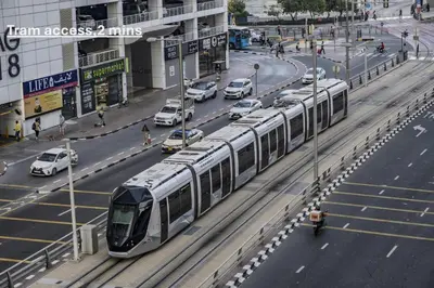 a train traveling down a city street with cars at Marina Majesty- Homely & Cozy 2BR, CanalView, Central Location in Dubai