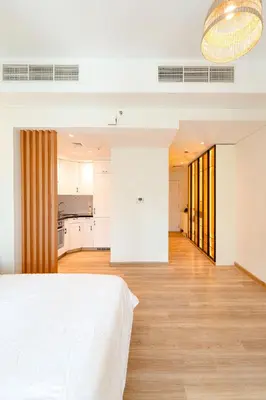 a bedroom with a white bed and a kitchen at Modern Studio I Boulevard View I Downtown Dubai in Dubai