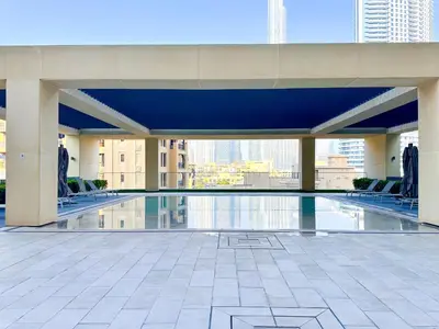 a swimming pool in a building with a view of the city at Amazing 1 Bedroom in Burj Royale Downtown in Dubai