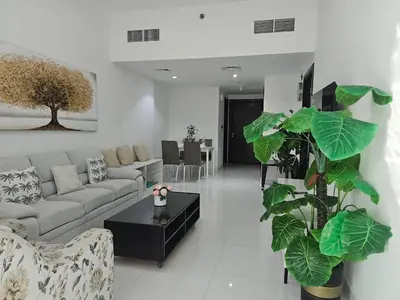 a living room with a couch and a table at Dubai Silicon Oasis Staycation in Dubai