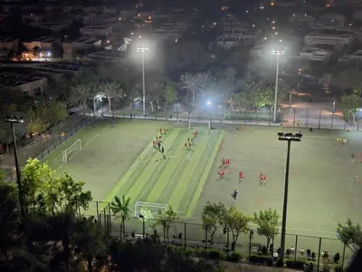 a soccer game on a soccer field at night at Dubai Silicon Oasis Staycation in Dubai