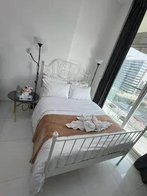 a white bed in a room with a large window at Dubai Silicon Oasis Staycation in Dubai
