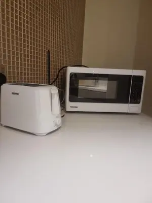 a microwave and a toaster oven sitting on a counter at 1 Bedroom Tower D Paramount Apt in Dubai
