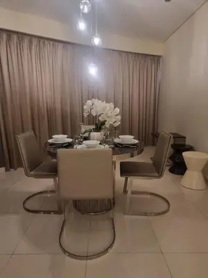 a dining room with a table with chairs and flowers at 1 Bedroom Tower D Paramount Apt in Dubai