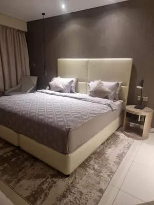 a bedroom with a large bed and a chair at 1 Bedroom Tower D Paramount Apt in Dubai