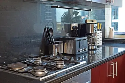 a kitchen with a stove top with a coffee maker at Stylish Marina View Apartment With Private Marina Walk Access in Dubai