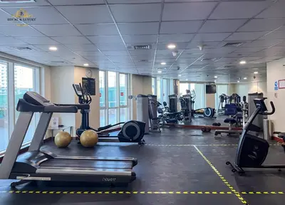 a gym with treadmills and exercise equipment in a building at Modern Studio at The Crescent Tower B, IMPZ - In the heart of Dubai in Dubai