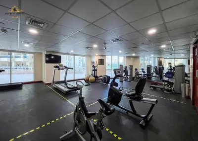 a gym with several treadmills and cardio machines at Modern Studio at The Crescent Tower B, IMPZ - In the heart of Dubai in Dubai