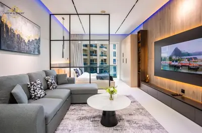 a living room with a couch and a tv at Modern Studio at The Crescent Tower B, IMPZ - In the heart of Dubai in Dubai