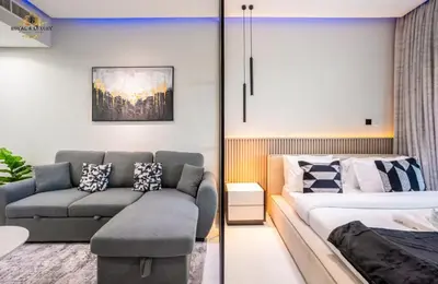 a living room with a bed and a couch at Modern Studio at The Crescent Tower B, IMPZ - In the heart of Dubai in Dubai