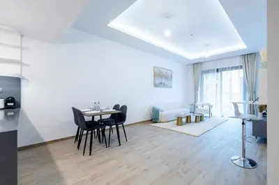 a living room with a table and chairs and a couch at Luxe 1BR in Citywalk with Pool Balcony & More in Dubai