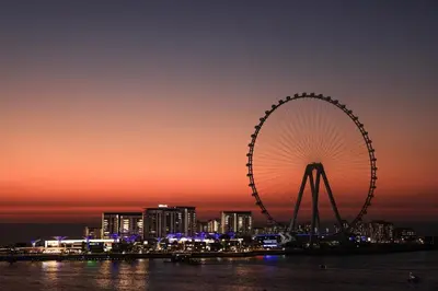 a large ferris wheel in a city at night at Cozy Dubai Eye & Sunset Views - JBR Beachfront - Gym & Pool - Free Parking in Dubai