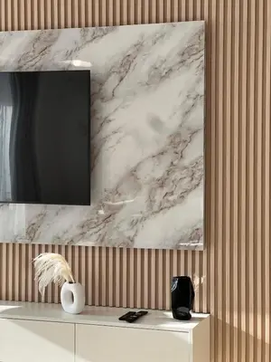 a living room with a tv on a wall at Cozy Dubai Eye & Sunset Views - JBR Beachfront - Gym & Pool - Free Parking in Dubai