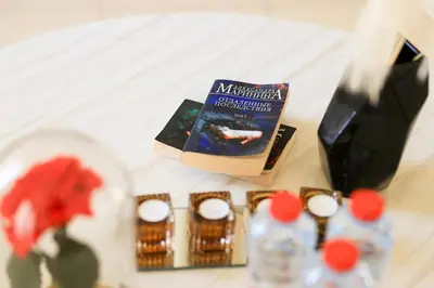 a table with a book and other items on it at Cozy Dubai Eye & Sunset Views - JBR Beachfront - Gym & Pool - Free Parking in Dubai