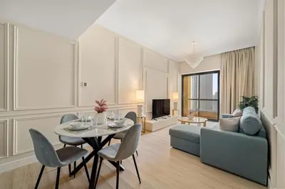 a living room with a table and chairs and a couch at FIRST CLASS 2BR Breathtaking Beach Views in Dubai
