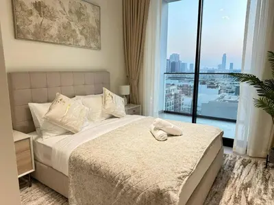 a bedroom with a large bed with a large window at Bright 1br Jvc Balcony & Free Parking in Dubai