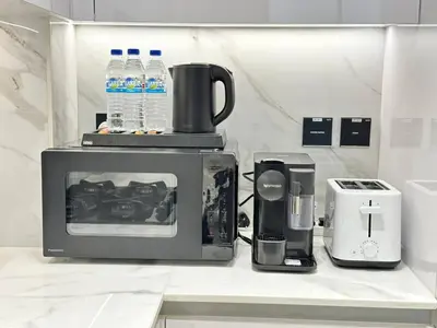 a kitchen counter with a microwave and a coffee maker at Bright 1br Jvc Balcony & Free Parking in Dubai