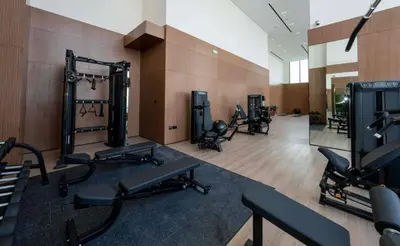 a gym with a row of exercise equipment in a room at Bright 1br Jvc Balcony & Free Parking in Dubai