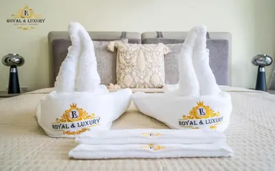 two towels with the crown on them sitting on a bed at Chic 1-Bedroom Haven in Standpoint A Tower, Downtown Dubai in Dubai