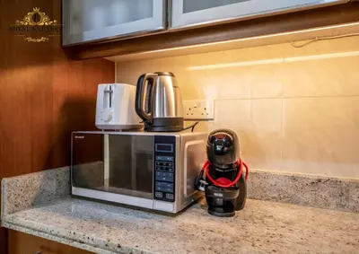 a microwave oven sitting on a kitchen counter with a helmet at Chic 1-Bedroom Haven in Standpoint A Tower, Downtown Dubai in Dubai
