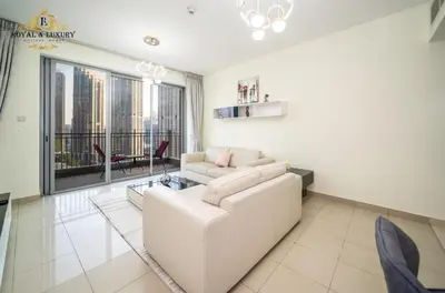 a living room with a white couch and a large window at Chic 1-Bedroom Haven in Standpoint A Tower, Downtown Dubai in Dubai
