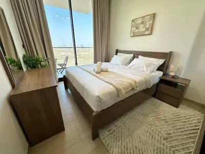 a bedroom with a bed and a large window at Modern 1br In Jvc Balcony, Pool & Parking in Dubai
