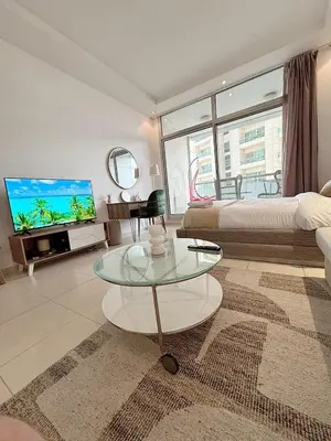 a living room with a couch and a tv and a table at Chic Studio in Dubai Marina in Dubai
