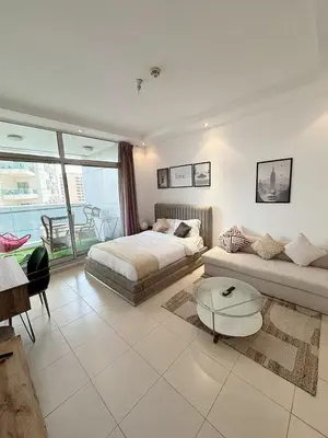 a bedroom with a bed and a couch and a table at Chic Studio in Dubai Marina in Dubai