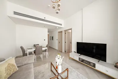 a living room with a large television and a table at Elegant 1 BR in Empire Residence in Dubai