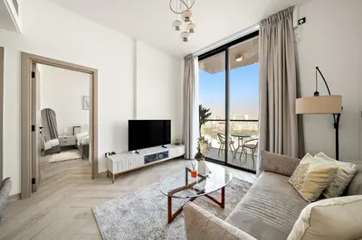 a living room with a couch and a tv at Elegant 1 BR in Empire Residence in Dubai