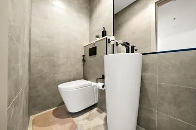 a bathroom with a white toilet in a room at Elegant 1 BR in Empire Residence in Dubai