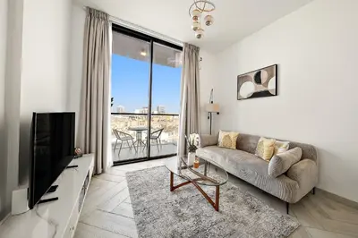 a living room with a couch and a television at Elegant 1 BR in Empire Residence in Dubai