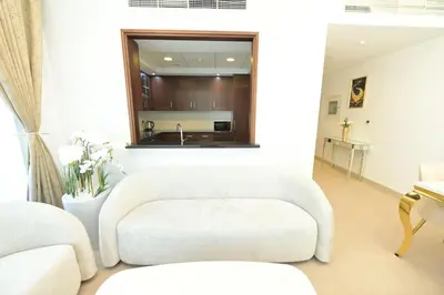 a living room with a white couch and a chair at La Vista Holiday Home with burj khalifa & fountain view in Dubai