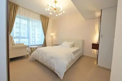 a bedroom with a white bed and a window at La Vista Holiday Home with burj khalifa & fountain view in Dubai