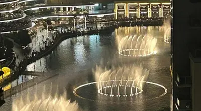 a large fountain in the water at night at La Vista Holiday Home with burj khalifa & fountain view in Dubai