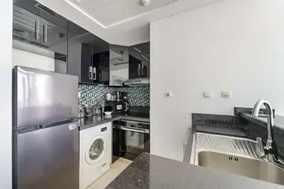 a kitchen with a stainless steel refrigerator and a dishwasher at Silkhaus Comfy 1BR in Botanica Tower near Dubai Marina in Dubai