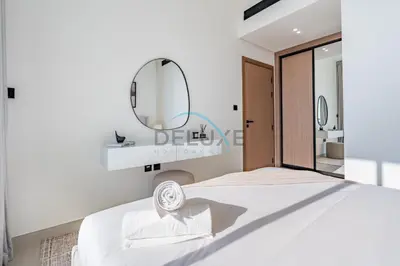 a bedroom with a white bed and a mirror at Cozy 1BR with Balcony in Binghatti House, Jumeirah Village Circle by Deluxe Holiday Homes in Dubai