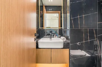 a bathroom with a white sink and a mirror at Cozy 1BR with Balcony in Binghatti House, Jumeirah Village Circle by Deluxe Holiday Homes in Dubai