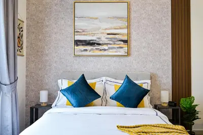 a bedroom with a bed with blue and yellow pillows at Modern Studio in Discovery Gardens, Close to Metro in Dubai