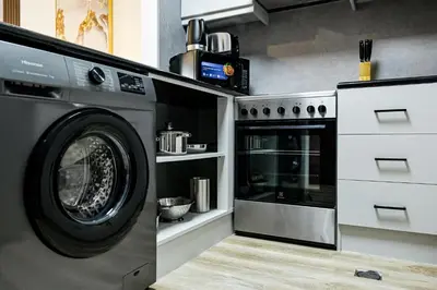 a kitchen with a washing machine and a stove at Modern Studio in Discovery Gardens, Close to Metro in Dubai