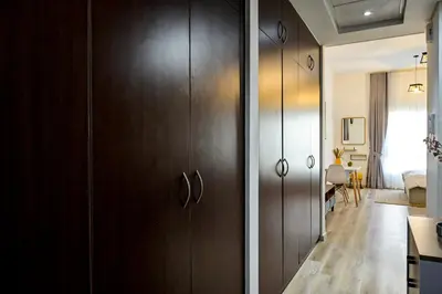 a kitchen with wooden cabinets and a living room at Modern Studio in Discovery Gardens, Close to Metro in Dubai