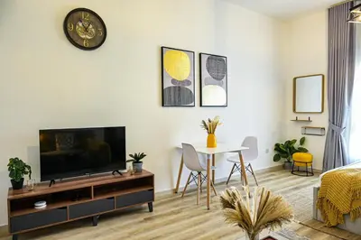 a living room with a tv and a table at Modern Studio in Discovery Gardens, Close to Metro in Dubai