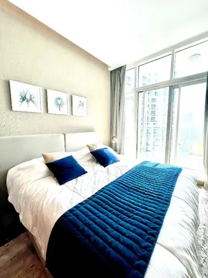 a bedroom with a large bed with blue pillows at Luxury Studio Near Burj Khalifa in Dubai