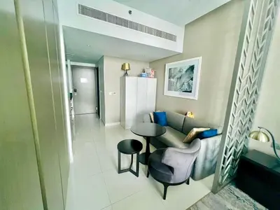 a living room with a couch and a table in a room at Luxury Studio Near Burj Khalifa in Dubai